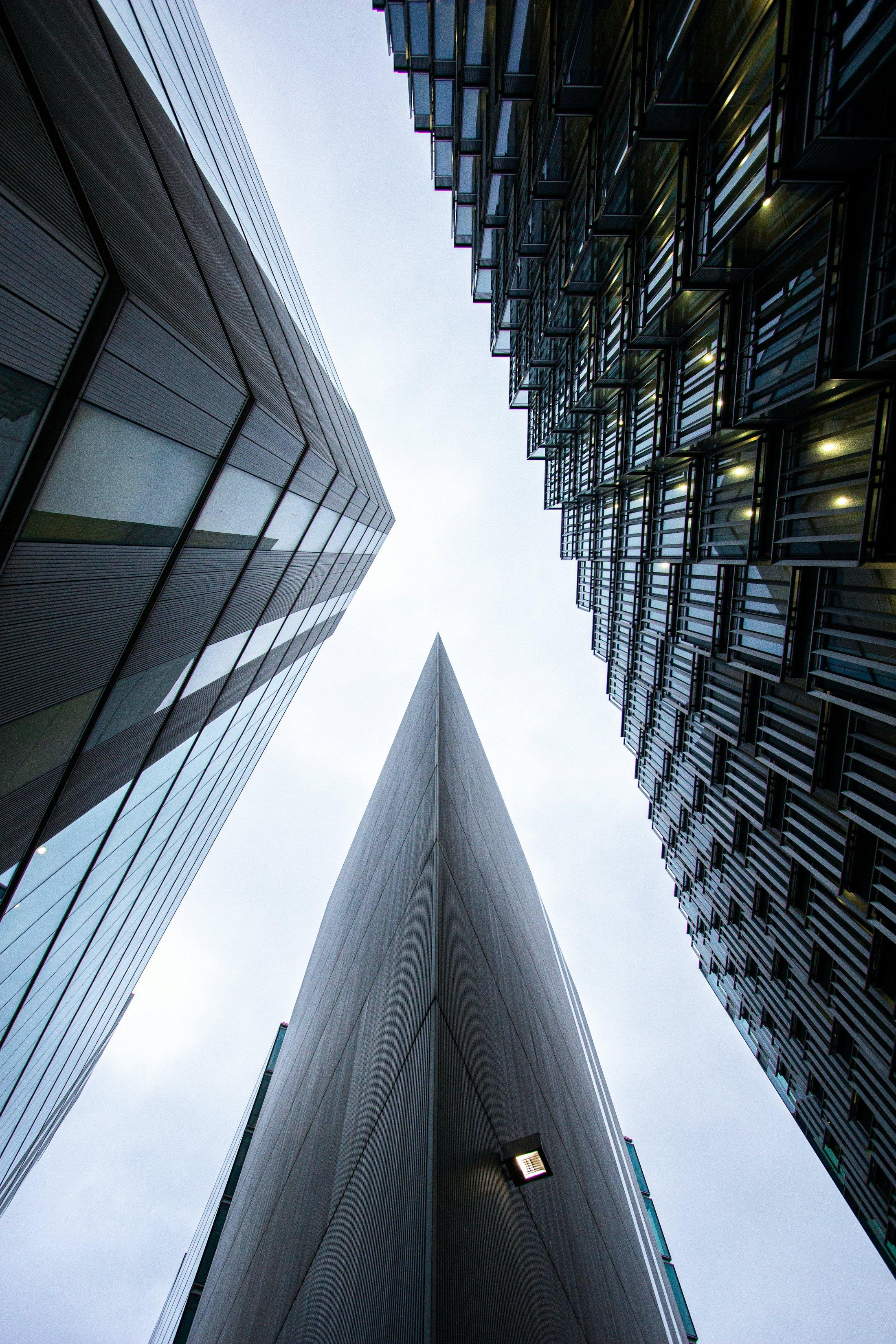 Two towers meeting against the sky, seen from below.