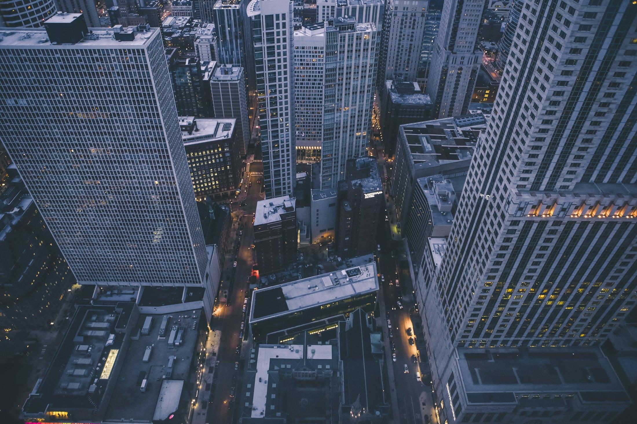 Manhattan towers seen from far above, streets lit below.
